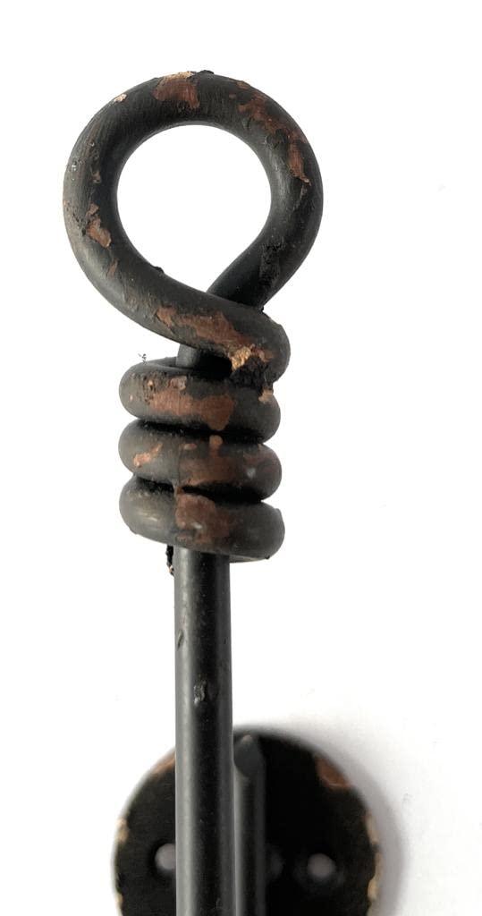 Dettaglio della finitura anticata del gancio a parete in metallo