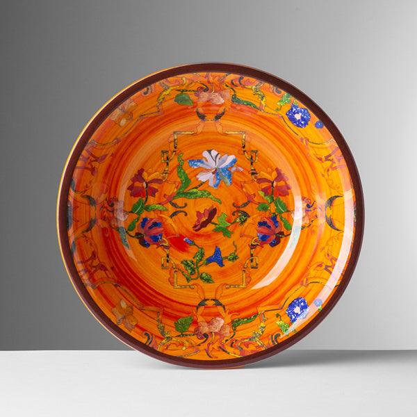 Piatto fondo Pancale arancio di Mario Luca Giusti in melamina, con decoro floreale vivace e bordo ornamentale giallo e blu