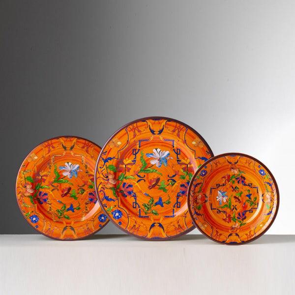 Set piatti Pancale arancio di Mario Luca Giusti in melamina decorata, con piatto piano, fondo e frutta in stile floreale su fondo arancio brillante