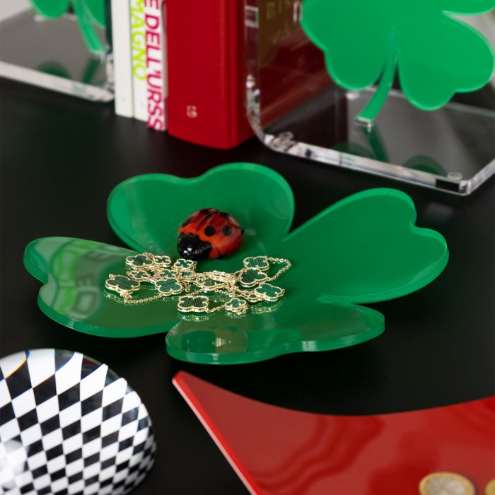 Vuota tasche quadrifoglio Vesta in cristallo acrilico verde con gioielli e coccinella decorativa, su tavolo moderno