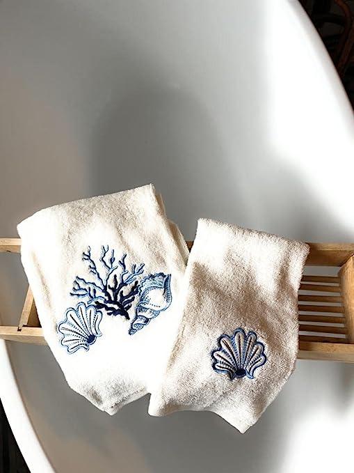 Set viso e ospite in spugna bianca con motivi marini ricamati a mano in blu, perfetto per ambienti eleganti e yacht
