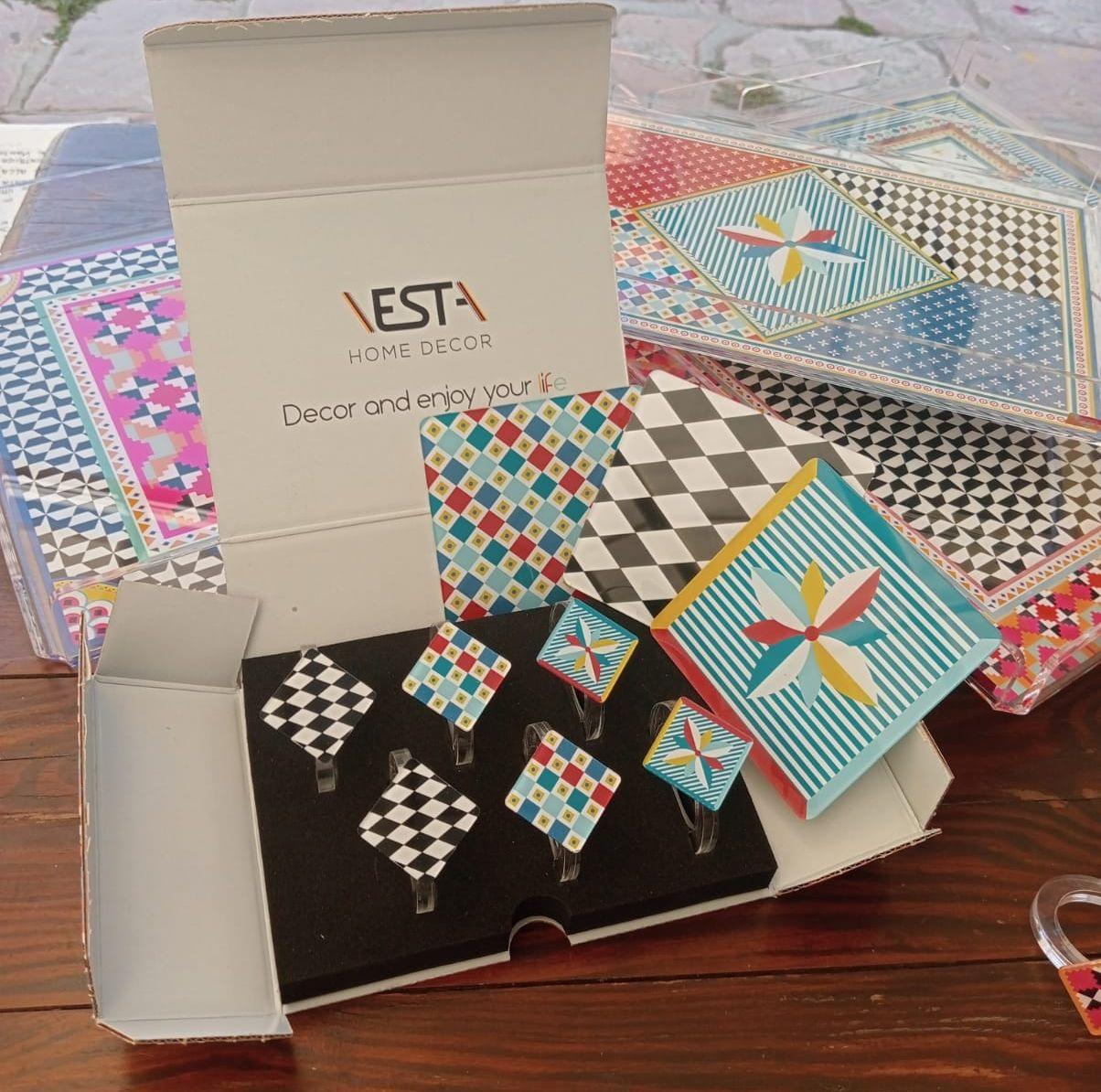 Ferma tovaglioli modello Modern decorato con motivi geometrici, abbinati ai sotto bottiglia e vassoi coordinati in stile mediterraneo, perfetti per mise en place originali e colorate.