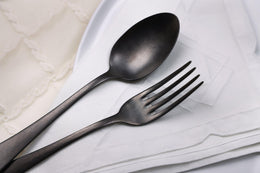 Posate in metallo scuro su tovagliolo bianco – design elegante per la tavola