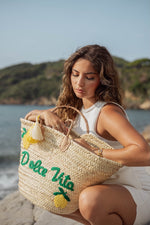 Modella con borsa in paglia ricamata "Dolce Vita" con limoni, manici effetto cuoio e nappine decorative – Marika Selection.