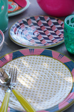 Piatti Modern Vesta in melamina con design geometrico multicolor, set da tavola apparecchiato con posate e bicchieri colorati