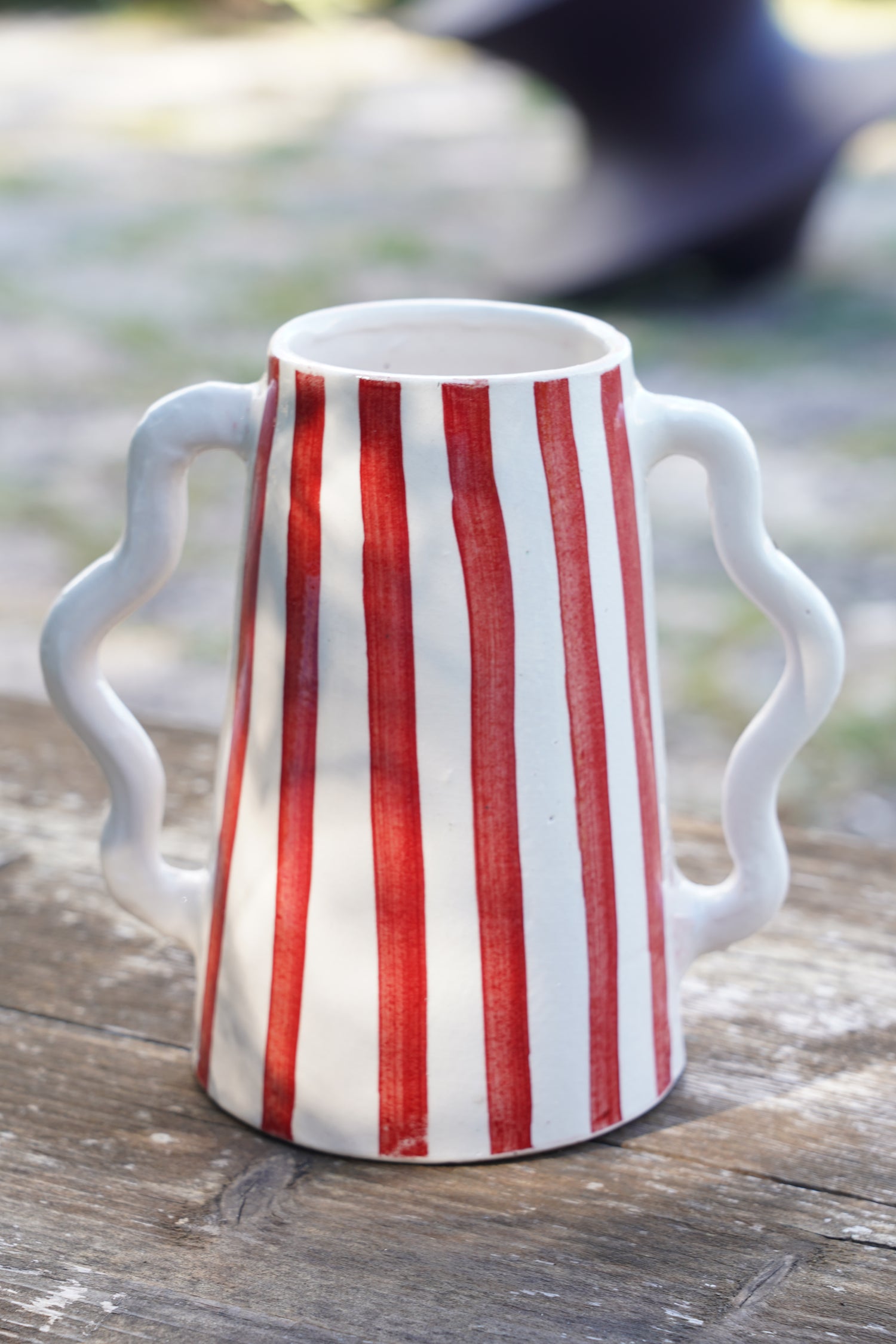 Brocca in ceramica artigianale con righe verticali rosse e doppio manico ondulato, stile rustico elegante