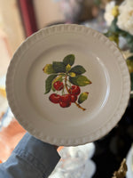 Piatto vintage con ciliegie rosse e foglie verdi, stile classico