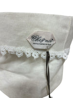 Dettaglio etichetta "Chez Moi fatto a manoi  in Italia" su cestino in lino con pizzo, artigianato italiano elegante.