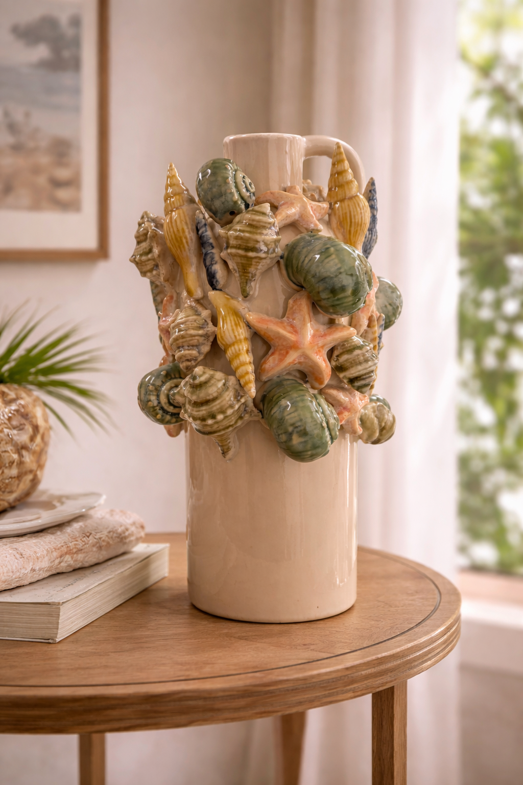 Vaso anfora in ceramica con conchiglie e stelle marine in rilievo, ambientato su tavolo in legno in un interno luminoso stile mediterraneo