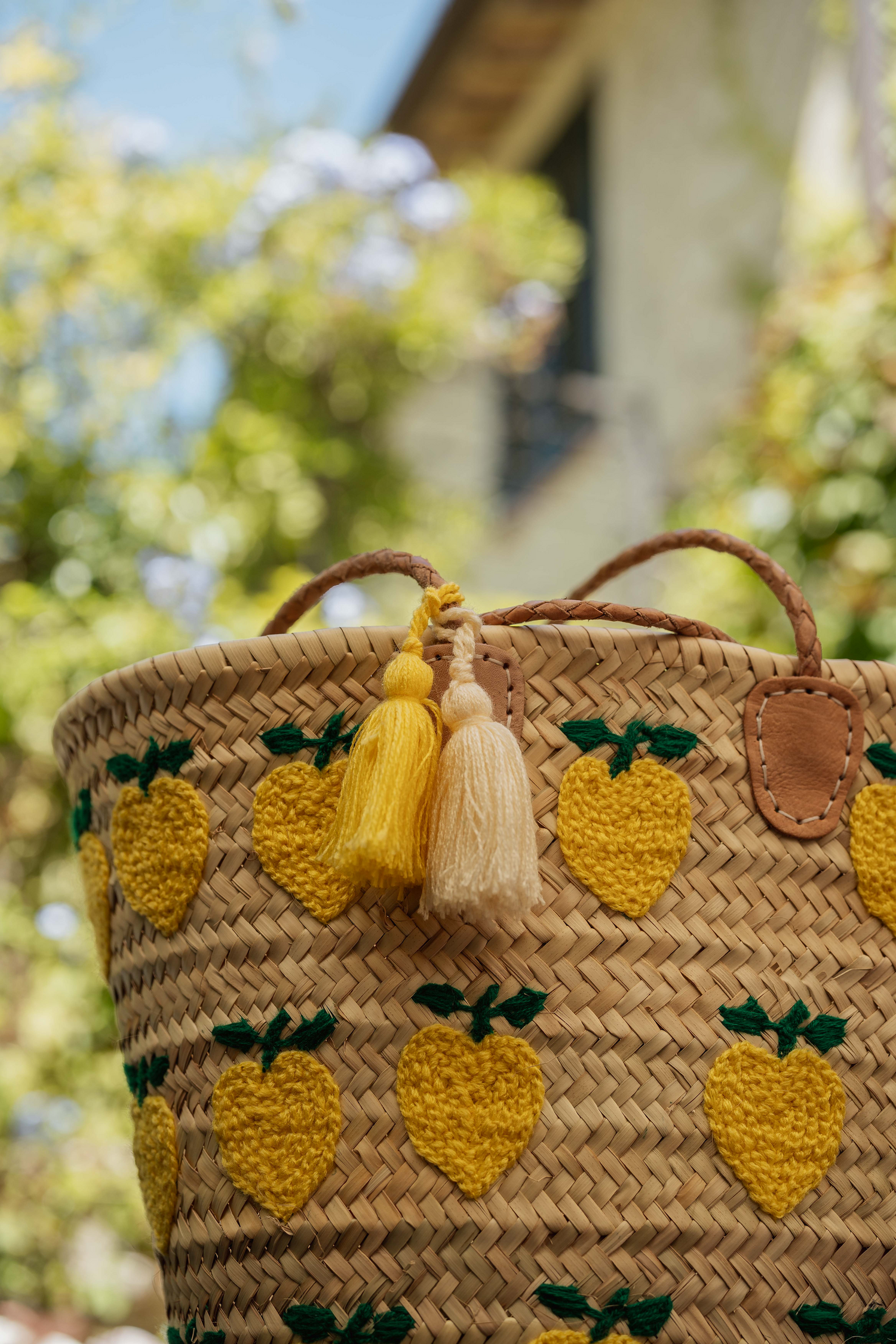 Borsa estiva in paglia intrecciata con limoni ricamati su tutta la superficie e doppia nappa gialla e bianca