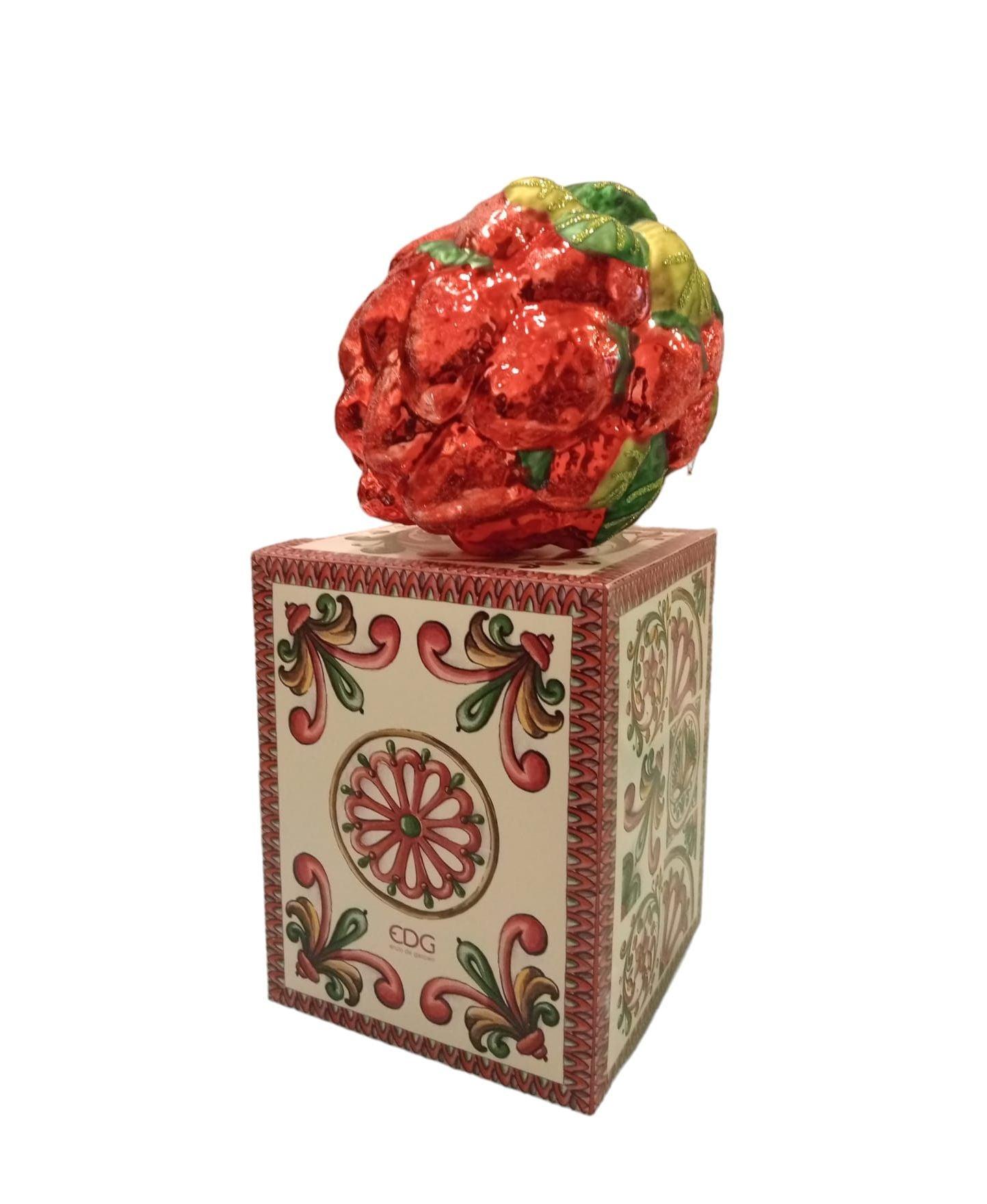 Sfera di Natale in vetro decorata con fragole e foglie verdi, appoggiata sulla sua elegante scatola regalo