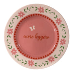 Piatto in porcellana rosa Ø16 cm con scritta “Cuore leggero”, fiori rosa, foglie verdi e piccola farfalla
