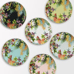  Collezione di piatti piani Exotic Jungle di Simone Guidarelli in diverse varianti colore con decorazioni tropicali e bordo dorato.