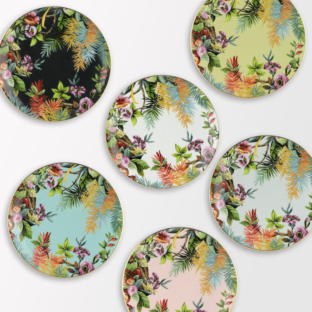  Collezione di piatti piani Exotic Jungle di Simone Guidarelli in diverse varianti colore con decorazioni tropicali e bordo dorato.