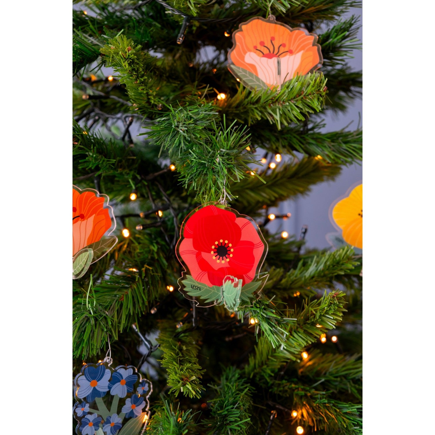 Decorazioni Funny Flowers di Vesta in acrilico appese all’albero di Natale con luci, in vari colori floreali.