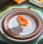 Fiore Funny Flowers di Vesta modello Petunia arancione utilizzato come segnaposto su una tavola apparecchiata con piatti decorati.