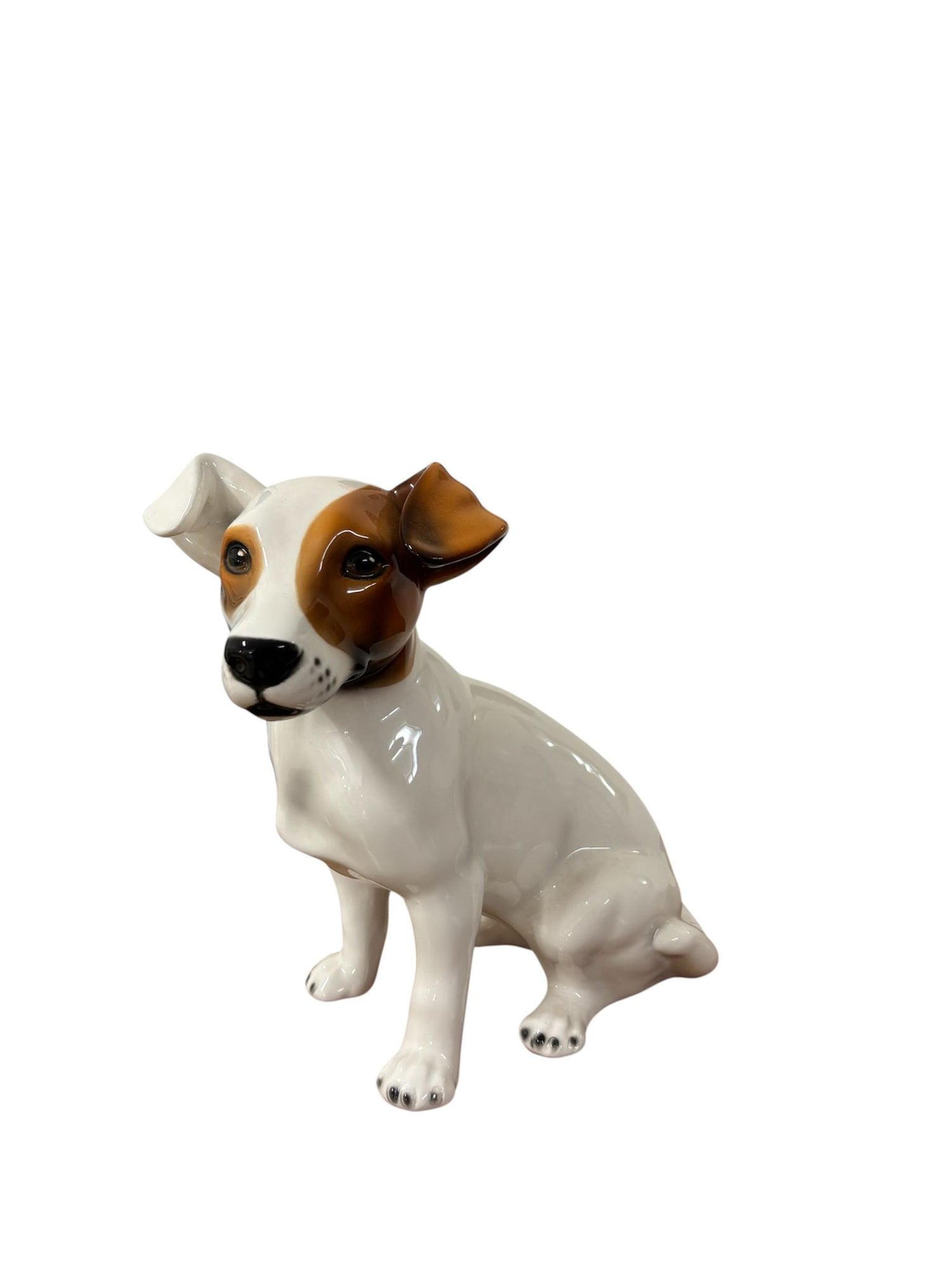 Primo piano espressivo del cane Jack Russell in ceramica, con smalto lucido e sguardo vivace. La lavorazione artigianale esalta ogni dettaglio con grande precisione.

Foto 3 – Vista laterale sinistra
Profilo elegante e proporzioni armoniose per questo Jack Russell artigianale in ceramica. L'effetto lucido riflette la luce e valorizza le sfumature della colorazione manuale.

Vista laterale destra, orecchio marrone in primo piano
Lateralmente si evidenzia l’orecchio marrone piegato, tratto distintivo