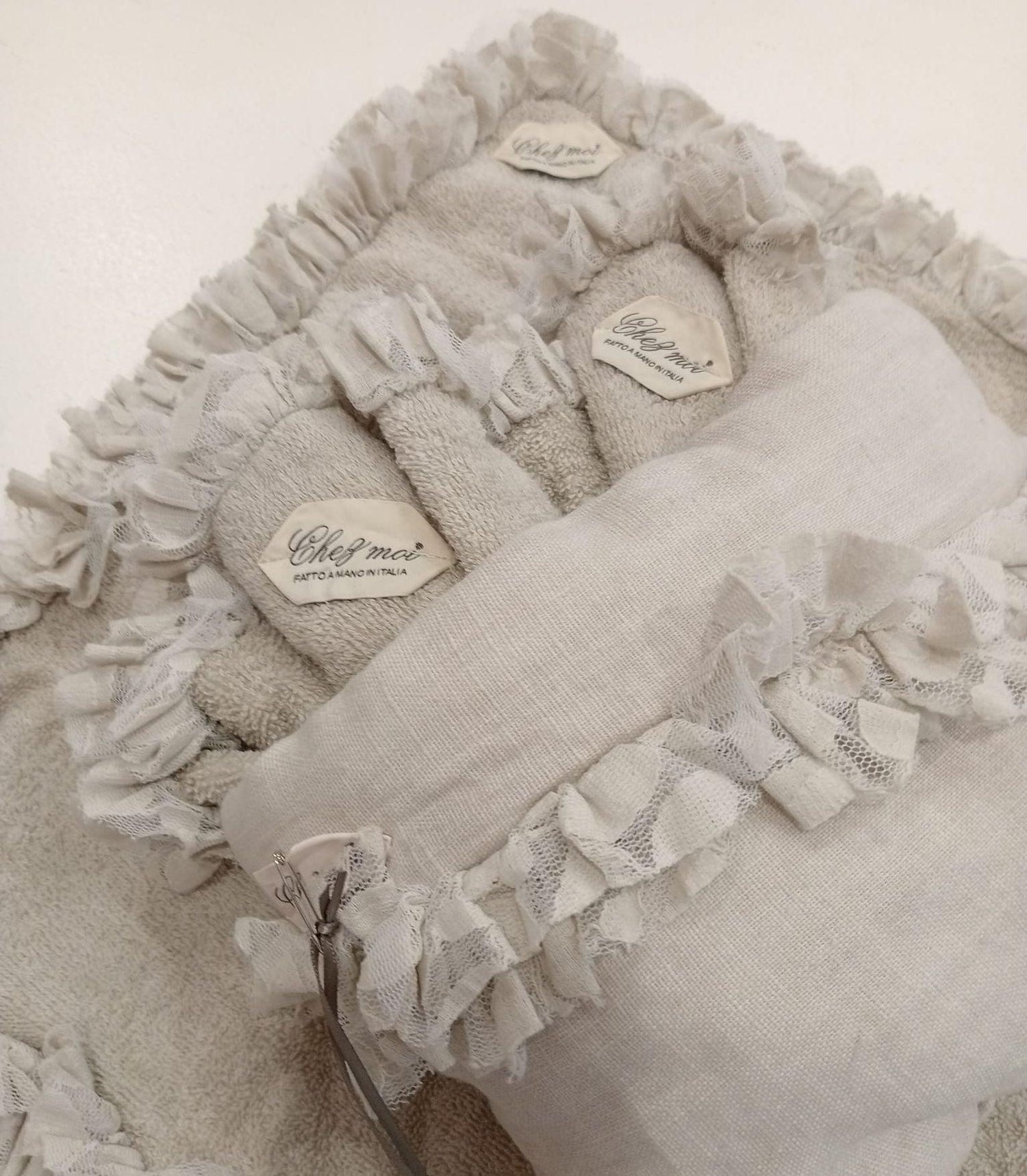 Dettaglio lavette in spugna con balza in pizzo e pochette in lino, fatte a mano in Italia, colore argilla, eleganza artigianale per il bagno