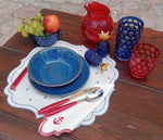 Dettaglio tavola apparecchiata con set lino cerato ricamato con ancore rosse e blu