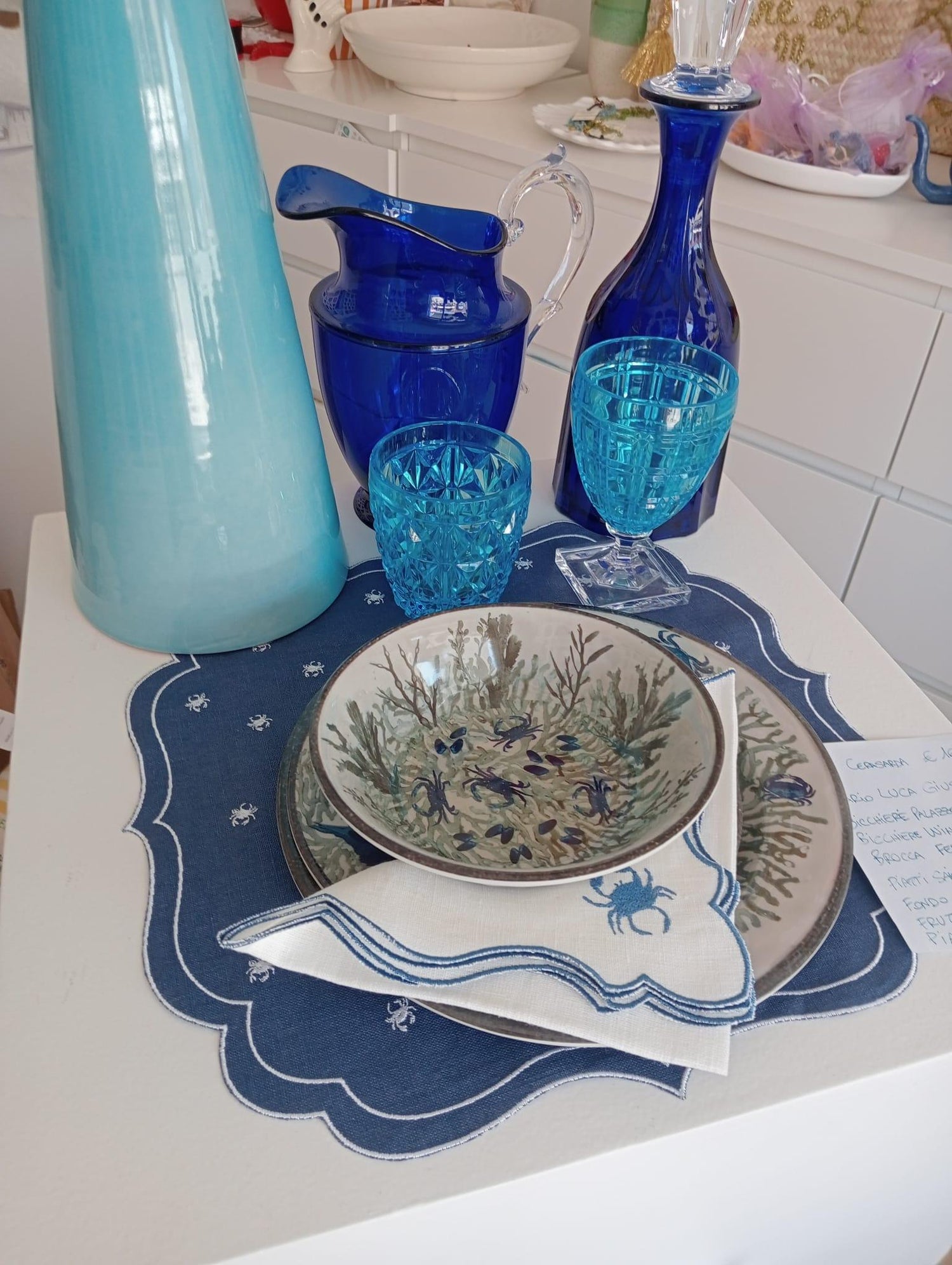 Apparecchiatura estiva con piatto fondo Oceano Illustrato in melamina, bicchieri in vetro blu, tovaglietta e tovagliolo ricamato a tema marino

