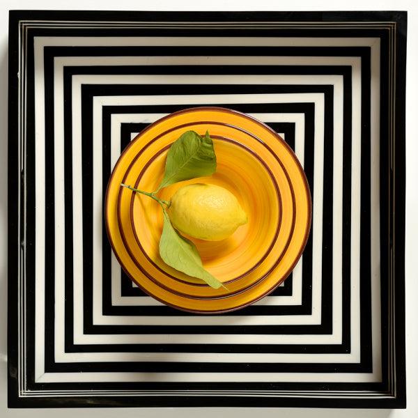 Set piatti Saint Tropez giallo Mario Luca Giusti in melamina vista dall'alto con limone al centro: fondo, piano e dessert.