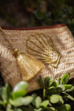 Dettaglio pochette in paglia Marika Selection con conchiglia ricamata in filo dorato e nappa decorativa boho chic