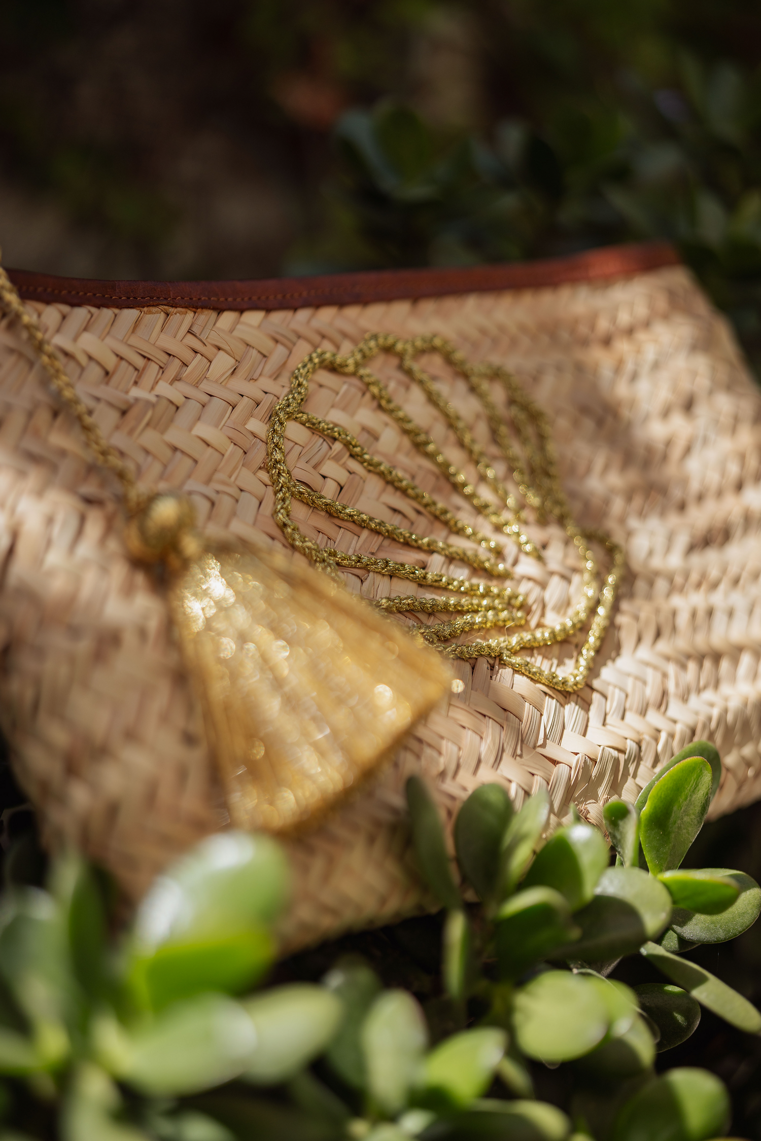 Dettaglio pochette in paglia Marika Selection con conchiglia ricamata in filo dorato e nappa decorativa boho chic