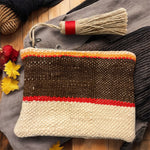 Pochette artigianale Marika Selection in tessuto berbero panna con fascia marrone e profilo rosso, con nappina laterale, stile boho etnico