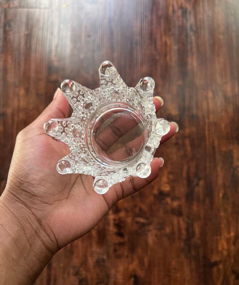 Portacandele in vetro trasparente a forma di corona Clayre & Eef visto dall’alto, tenuto in mano