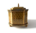 Dettaglio laterale del portaoggetti dorato con superficie martellata e base a piedini