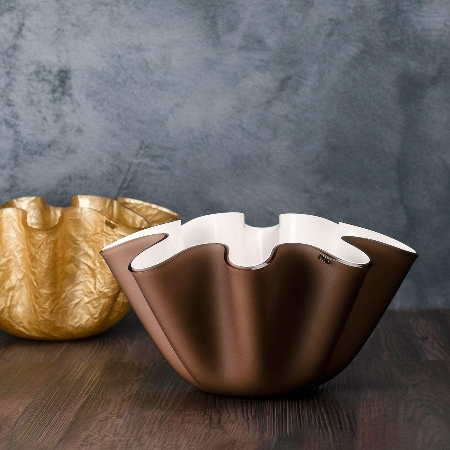 Due cntrotavola Vesta marrone interno bianco e oro in cristallo acrilico ondulato su tavolo in legno, stile italiano.