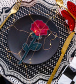 Rosa rossa Vesta Special Moment in plexiglas su tavola apparecchiata con luci decorative