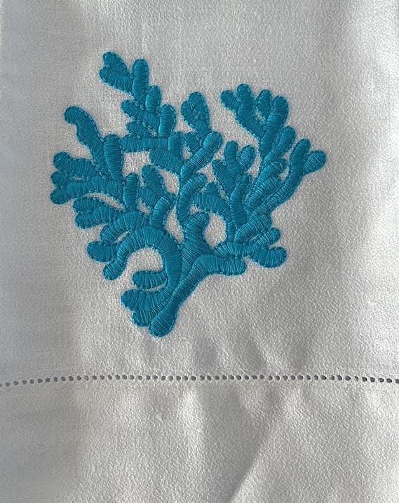 Primo piano del ricamo corallo azzurro su asciugamano in lino