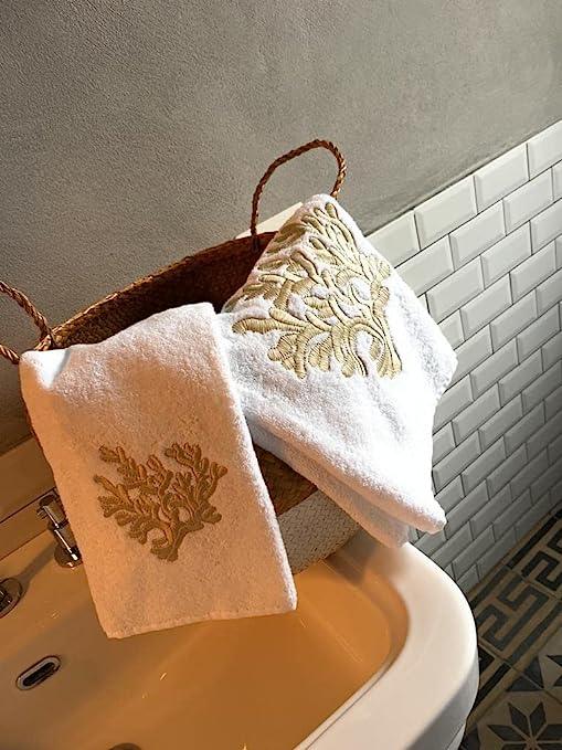 Set bagno Linea Coralli con ricamo beige esposto su lavabo in ceramica