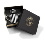 Teiera Souvenirs de Voyage Simone Guidarelli in porcellana bianca e nera con righe verticali e dettagli in vero oro, presentata in elegante scatola regalo nera e oro.