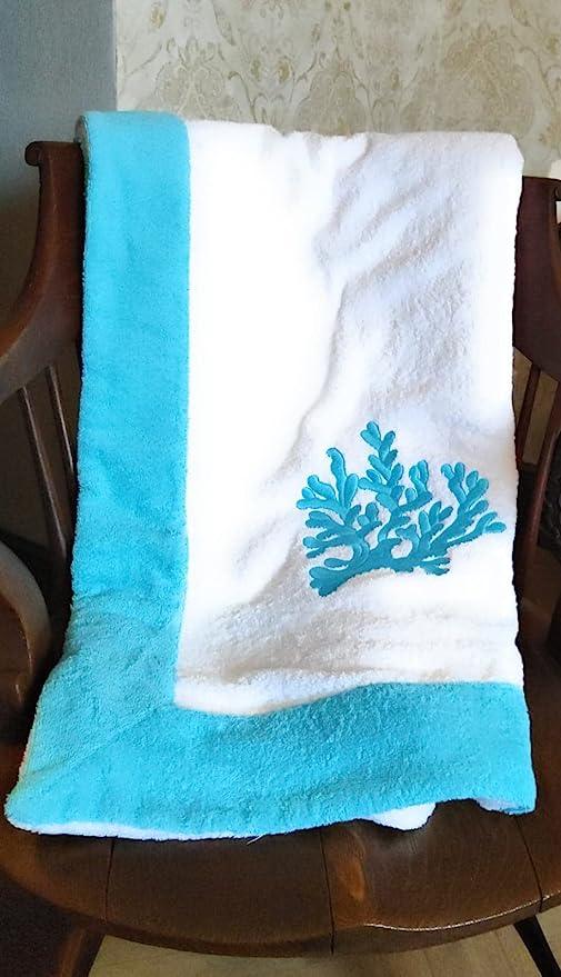 telo mare bianco con ricamo corallo azzurro e bordo azzurro su sedia vintage