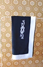 Telo mare bianco con bordo e ricamo nodo blu, in spugna artigianale Made in Italy della Linea Nodo, perfetto per yacht, spiaggia o piscina.