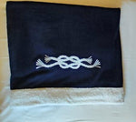 Telo mare bianco con bordo e ricamo nodo blu, in spugna artigianale Made in Italy della Linea Nodo, perfetto per yacht, spiaggia o piscina.