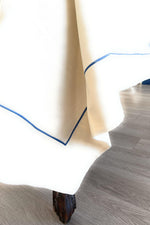 Dettaglio bordo tovaglia in cotone con profilo azzurro