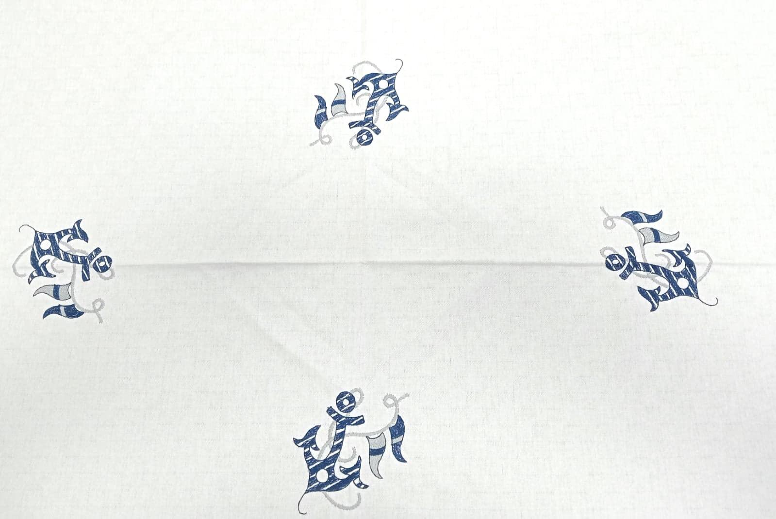 Ricami centrali ancora blu su tovaglia artigianale in cotone