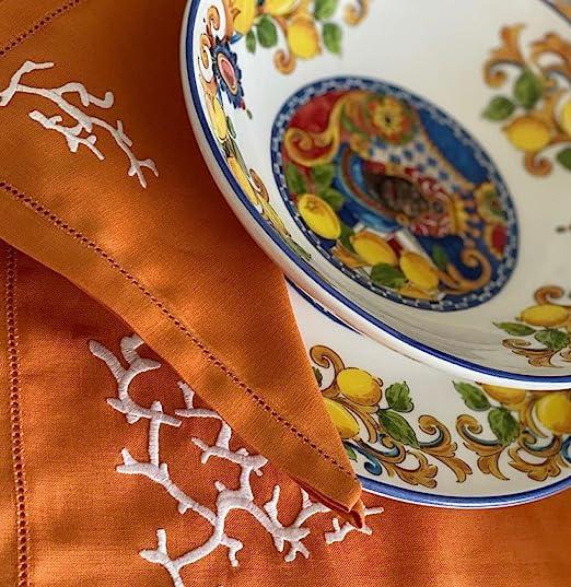 Dettaglio americano in lino arancio con ricamo bianco a forma di corallo e piatto decorato