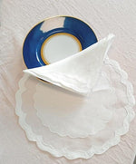 Set americano rotondo in organza con onde ricamate e tovagliolo piegato e piatto dessert