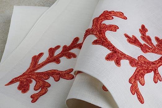 Particolare del ricamo artigianale a mano con corallo rosso su lino bianco – dettaglio di americano e tovagliolo di alto artigianato italiano