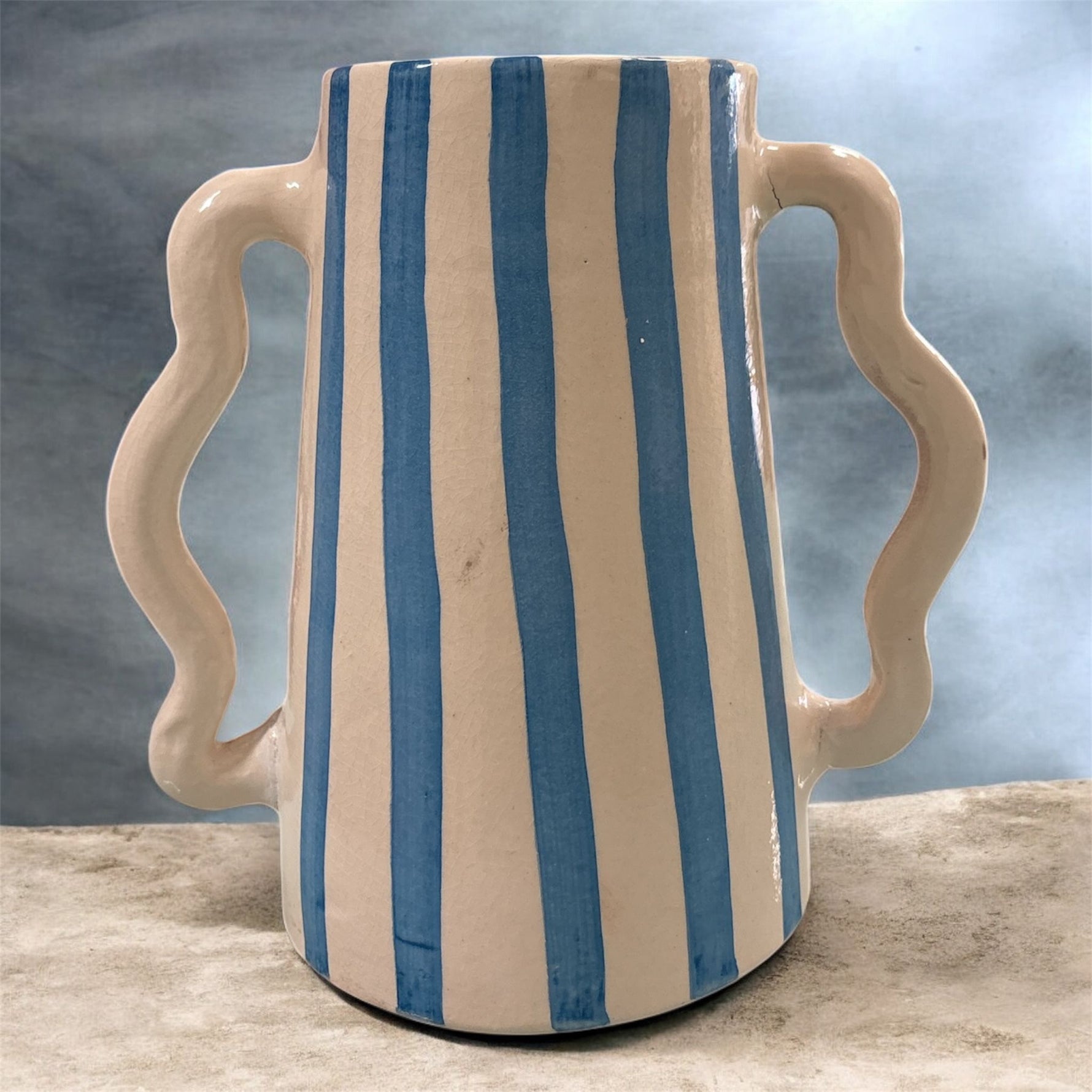 Brocca decorativa in ceramica con righe verticali azzurre e doppio manico sinuoso, design artigianale