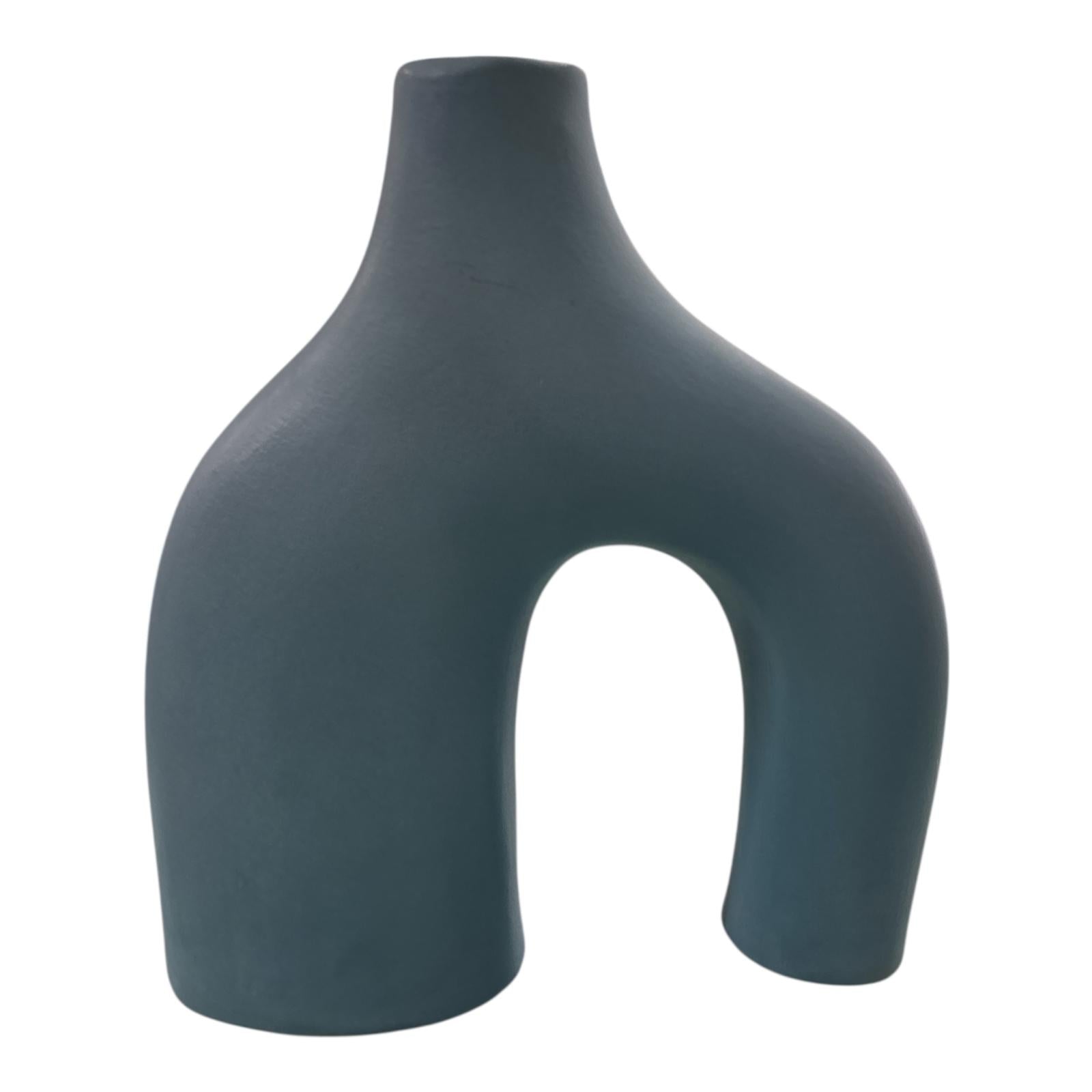 Vaso decorativo azzurro opaco con doppio piede, visto frontalmente su sfondo neutro.