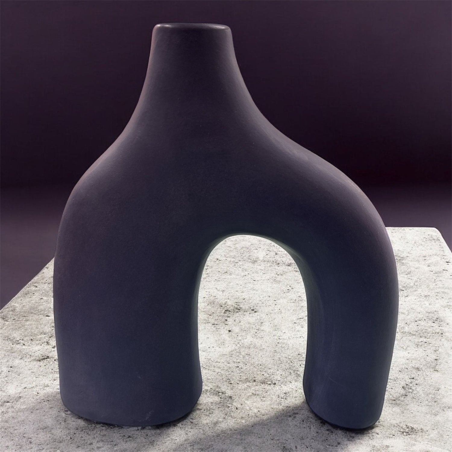 Vaso blu notte artigianale in ceramica su piano chiaro, design scultoreo.