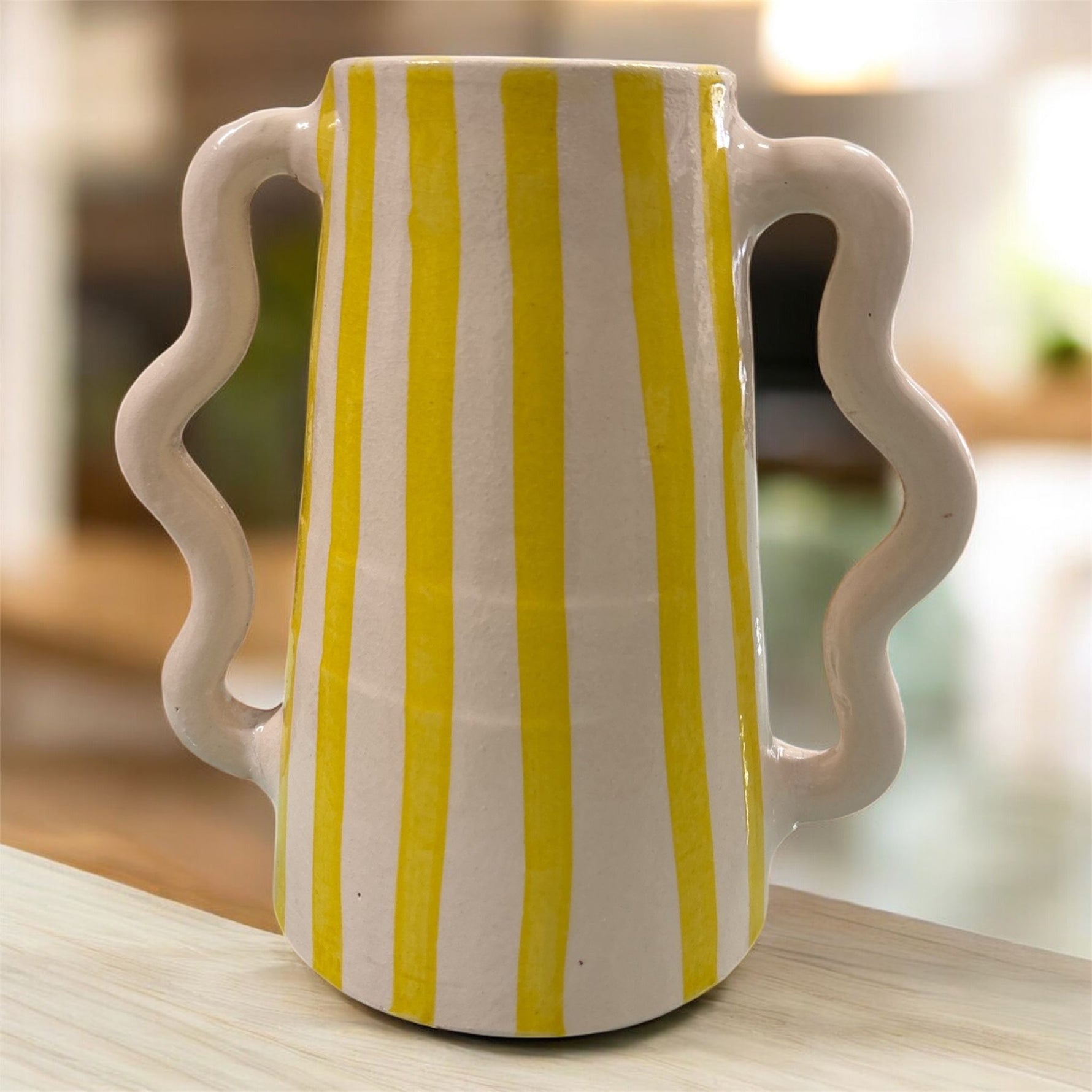 Brocca in ceramica con righe verticali gialle e doppio manico ondulato, stile solare artigianale