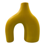 Vaso decorativo giallo in ceramica con doppio piede e forma contemporanea, visto frontalmente.