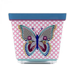 Vasetto JOY in acrilico con decorazione a farfalla colorata su sfondo rosa, visto frontalmente.