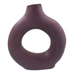 Vaso decorativo color lavanda in ceramica con foro centrale fotografato su sfondo neutro.